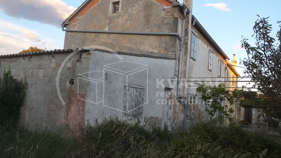 A detached stone house near the sea.